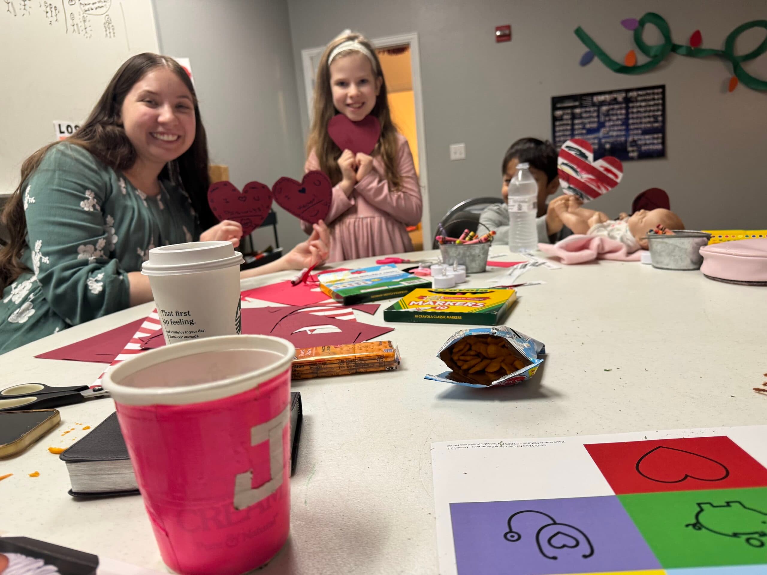 Children and a teacher making crafts at Faith Tabernacle